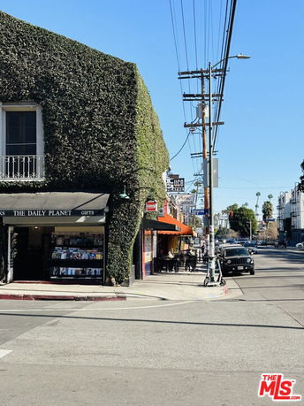 Front view of a two-story building with a gift shop on the ground floor, covered in greenery.