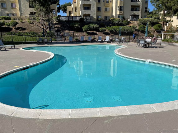 Outdoor swimming pool area with a curved design and surrounding lounge chairs.