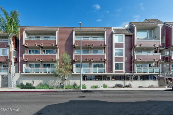 Front view of a multi-story apartment building with balconies.