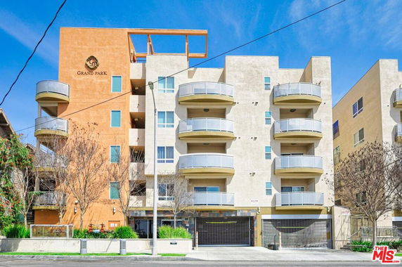 Front view of a multi-story apartment building with balconies.