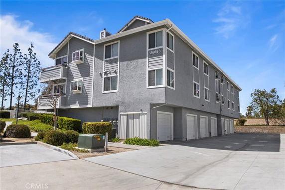 Front view of a multi-story residential building with multiple garage doors.