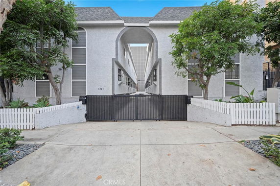 Front view of a multi-story building with arched entrance and gated entry.