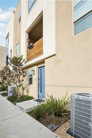 Front view of a multi-story building with a blue door and small balcony.