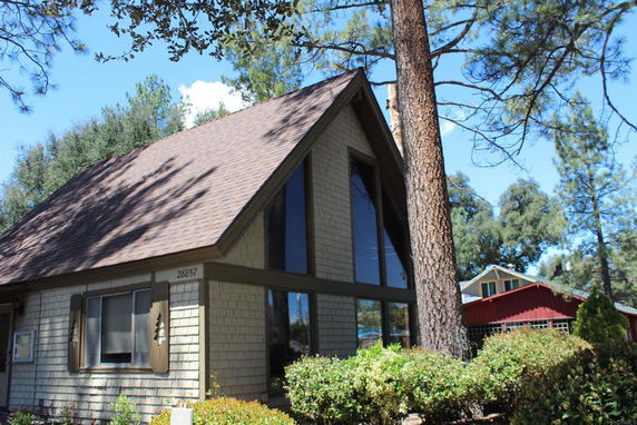 Front view of a house with A-frame architecture and large windows.