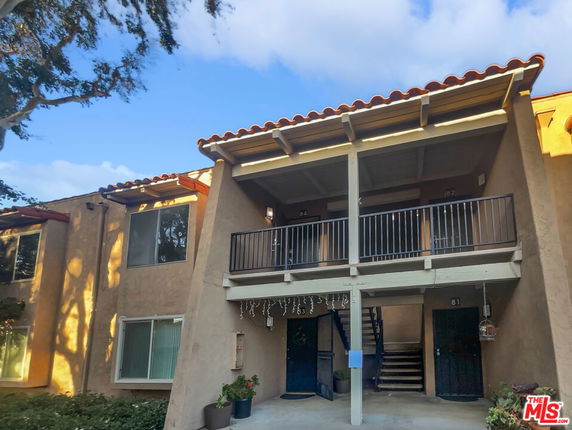 Front view of a two-story building with balconies and stair access.