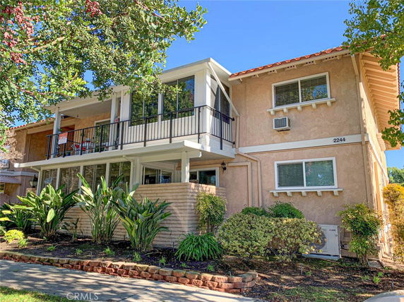 Front view of a two-story house with large windows and a balcony.
