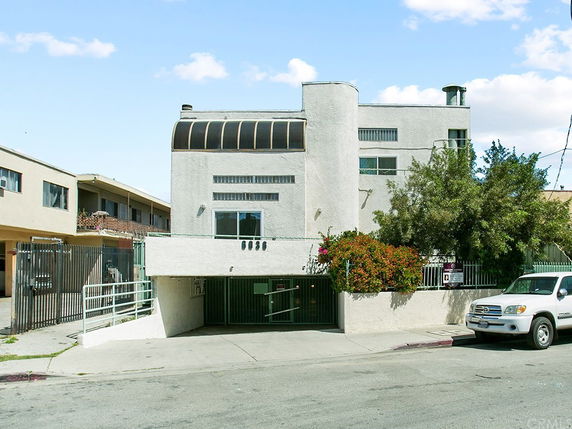 Front view of a multi-story building with a gated entrance