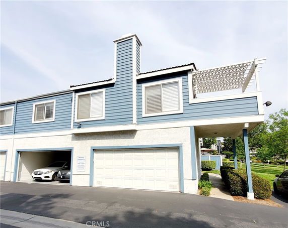 Front view of a two-story building with a garage and a balcony.