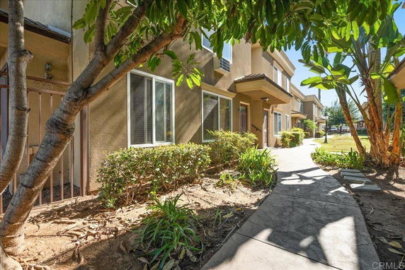 Front view of a two-story residential building with a walkway and landscaped area.