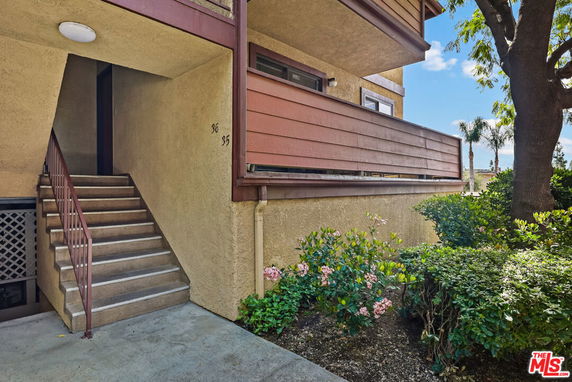 Front view of a building entrance with stairs leading to a door.