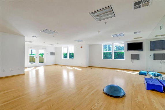 Room with wooden flooring and gym equipment.