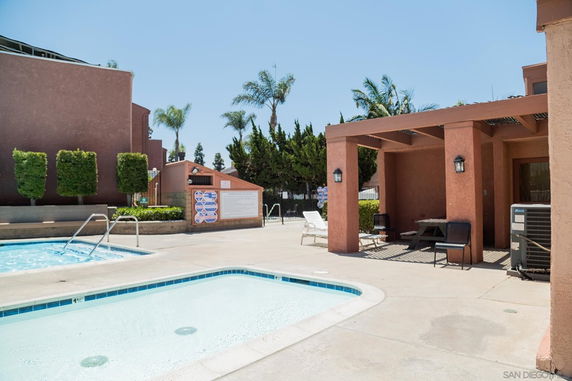 Outdoor area with two swimming pools and a shaded seating area.
