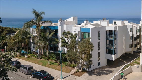 Front view of a multi-story building with modern design near the coastline.