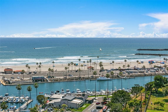 A view of the ocean with a marina and beach area in the foreground.