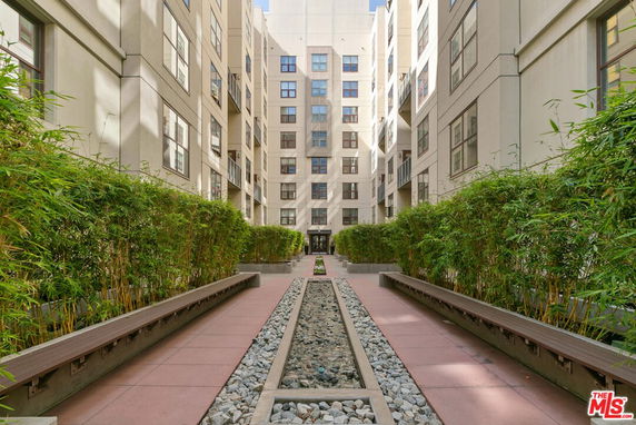 View of a multi-story building from a courtyard with pathways and plantings.