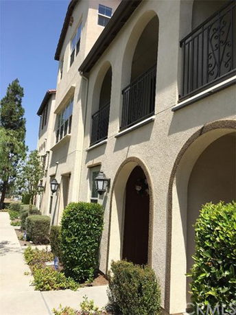 Front view of a multi-story building with arched balconies.