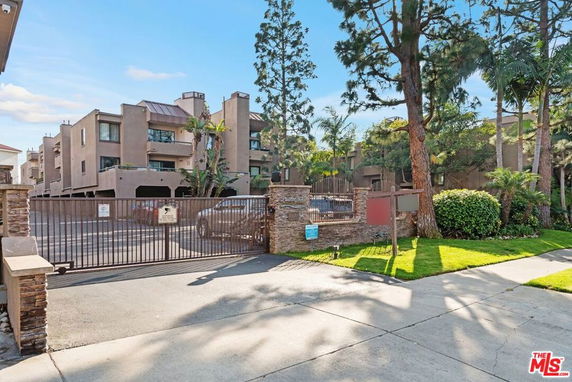 Front view of a multi-story residential building with gated entrance.