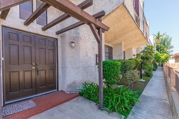 Front view of a building with a double door entrance and wooden pergola.