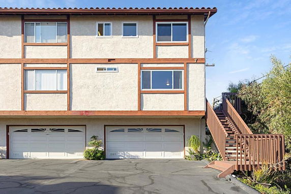 Front view of a two-story house with double garages and an exterior staircase.