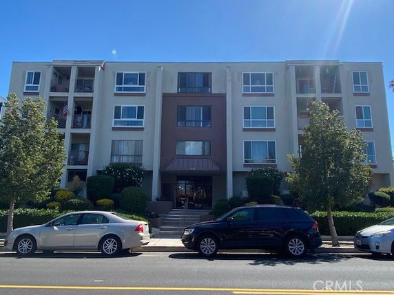 Front view of a multi-story apartment building with balconies.