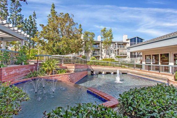 Outdoor view of a building complex with water features and greenery.