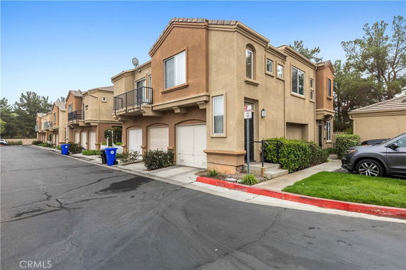 Front view of a two-story townhouse with garages in a row.