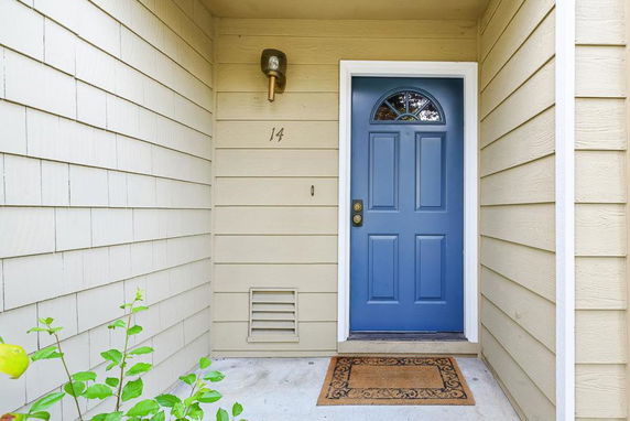 Front view of a house entrance with a blue door and light fixture.