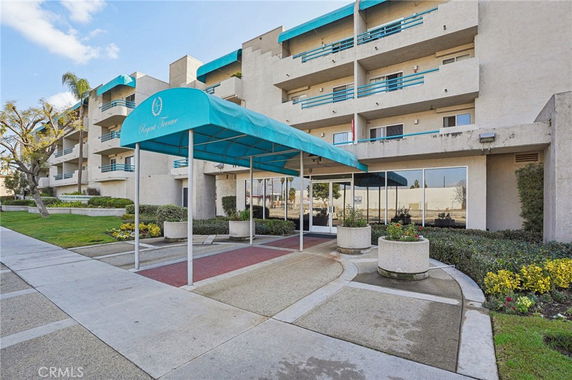 Front view of a multi-story building with a blue awning entrance.