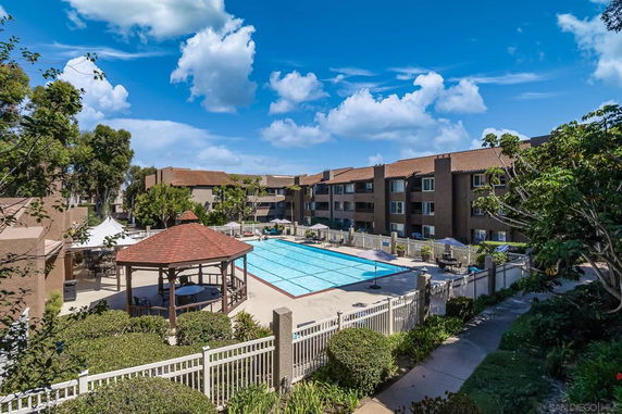 Outdoor swimming pool area with surrounding buildings.
