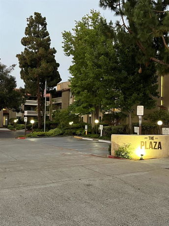 Front view of a multi-story building with surrounding trees and a driveway area.