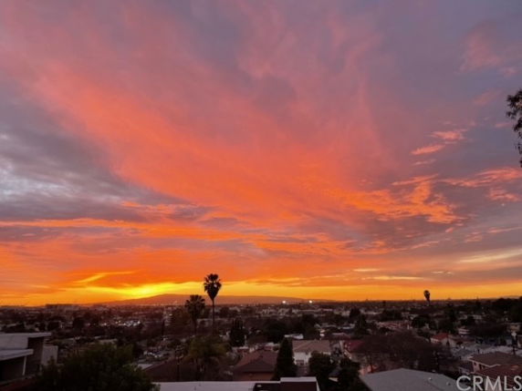 Panoramic sunset view over a cityscape with colorful sky.