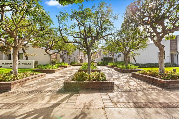 Front view of a villa complex with trees and landscaped pathways.
