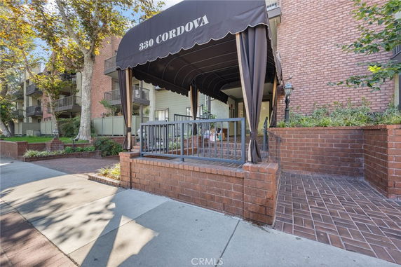 Front view of a building entrance with brick walls and a canopy over the doorway.