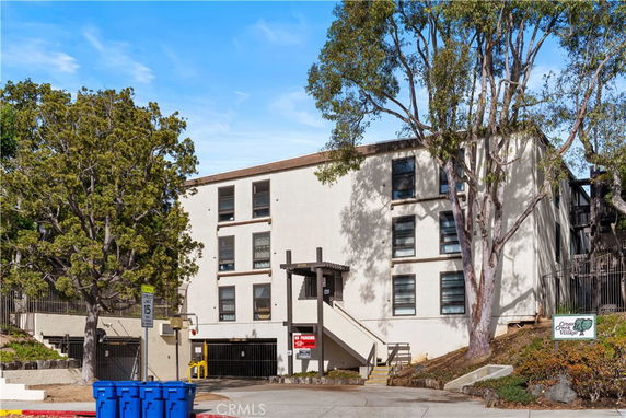 Front view of a multi-story residential building with a parking garage entrance.