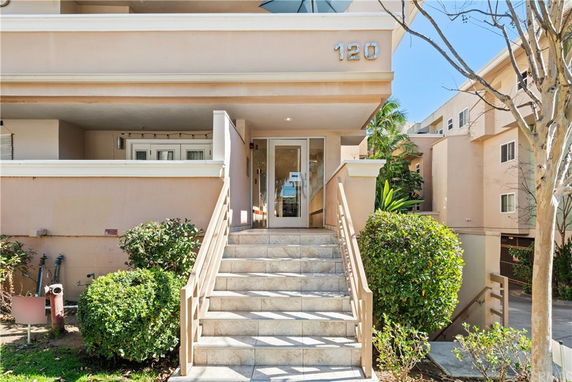 Front view of a building entrance with stairs and a covered walkway.