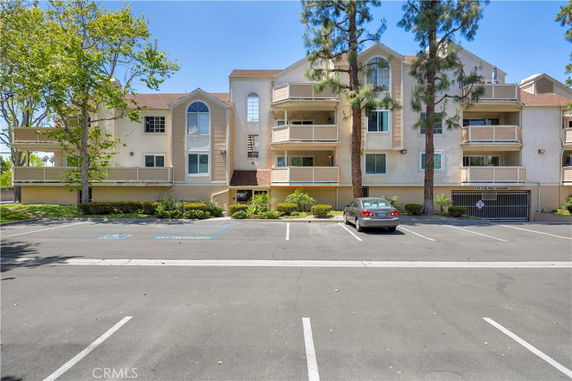 Front view of a multi-story residential building with balconies and large windows.