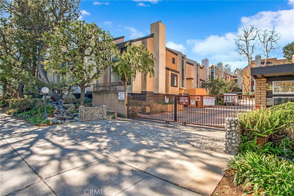 Front view of a multi-story residential building with gated entrance.