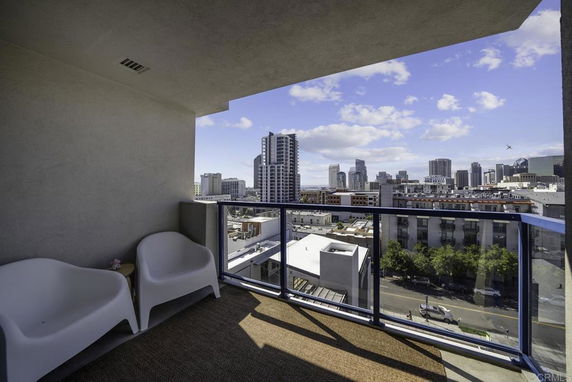 Balcony view overlooking a cityscape with high-rise buildings in the distance.