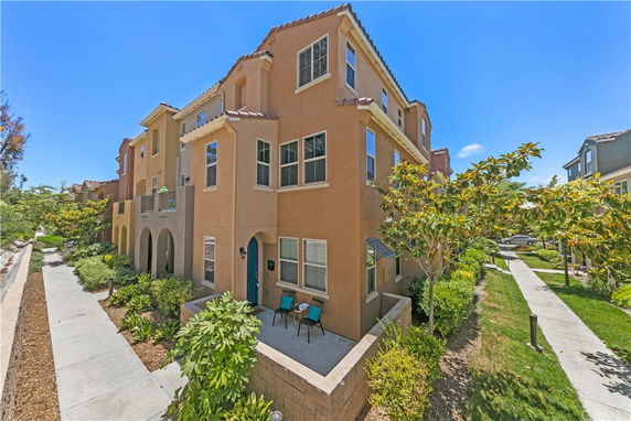 Front view of a multi-story residential building with tan exterior and multiple windows.