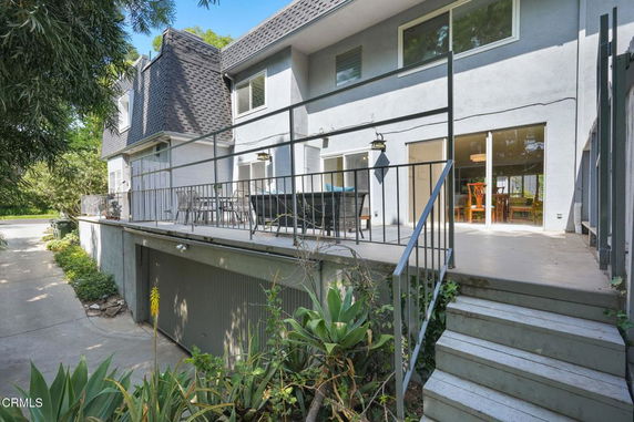 Front view of a two-story house with a terrace and garage below.