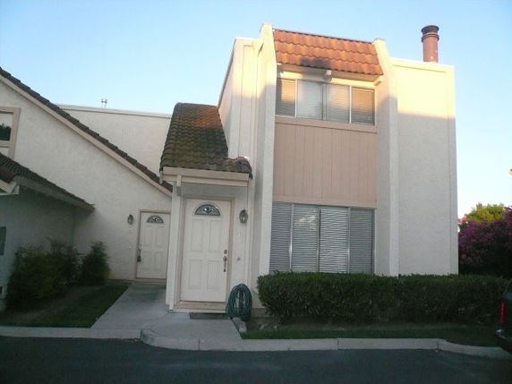 Front view of a two-story house with a chimney.