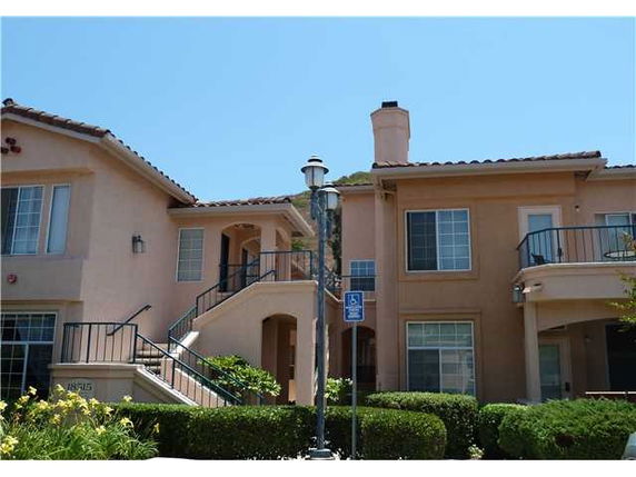 Front view of a multi-story residential building with balconies and a chimney.