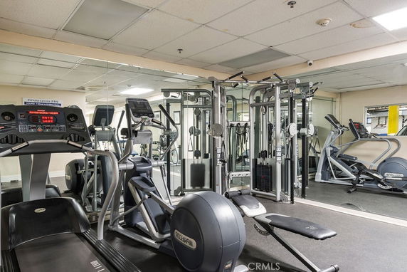 Indoor gym area with exercise equipment and mirrors.