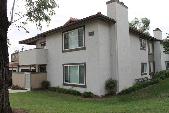 Front view of a two-story building with balconies and a light-colored exterior.
