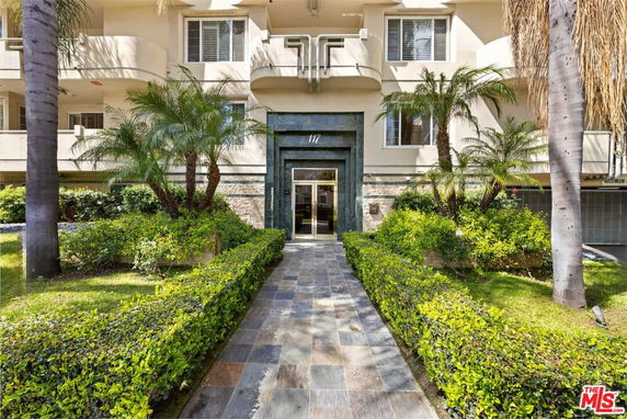 Front view of a multi-story building with a landscaped entrance.