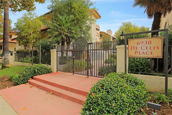 Entrance view of a building with a gated entry and sign displaying address.