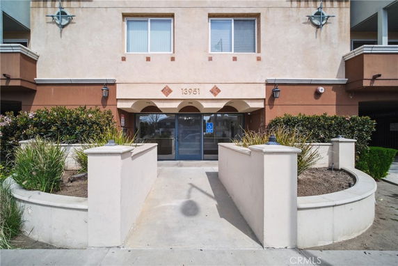Front view of a building entrance with landscaped walkway.