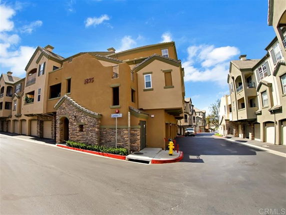 Front view of a multi-story residential building with stone and stucco facade.