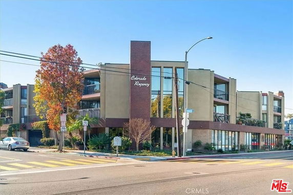 Front view of a multi-story modern building with large windows.
