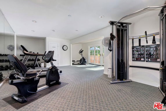 Indoor gym area with exercise equipment and mirrors.